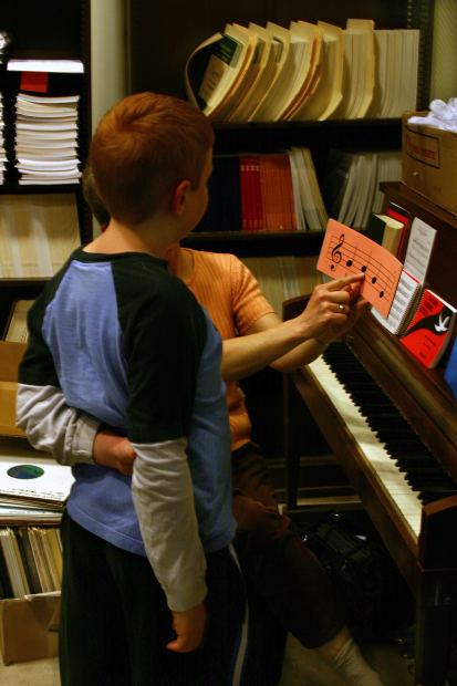 nanny instructing child with piano  